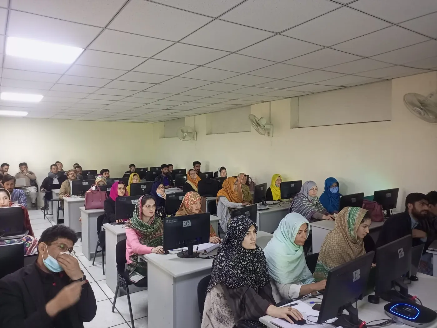 Teachers practising on computers during a hands-on training session
