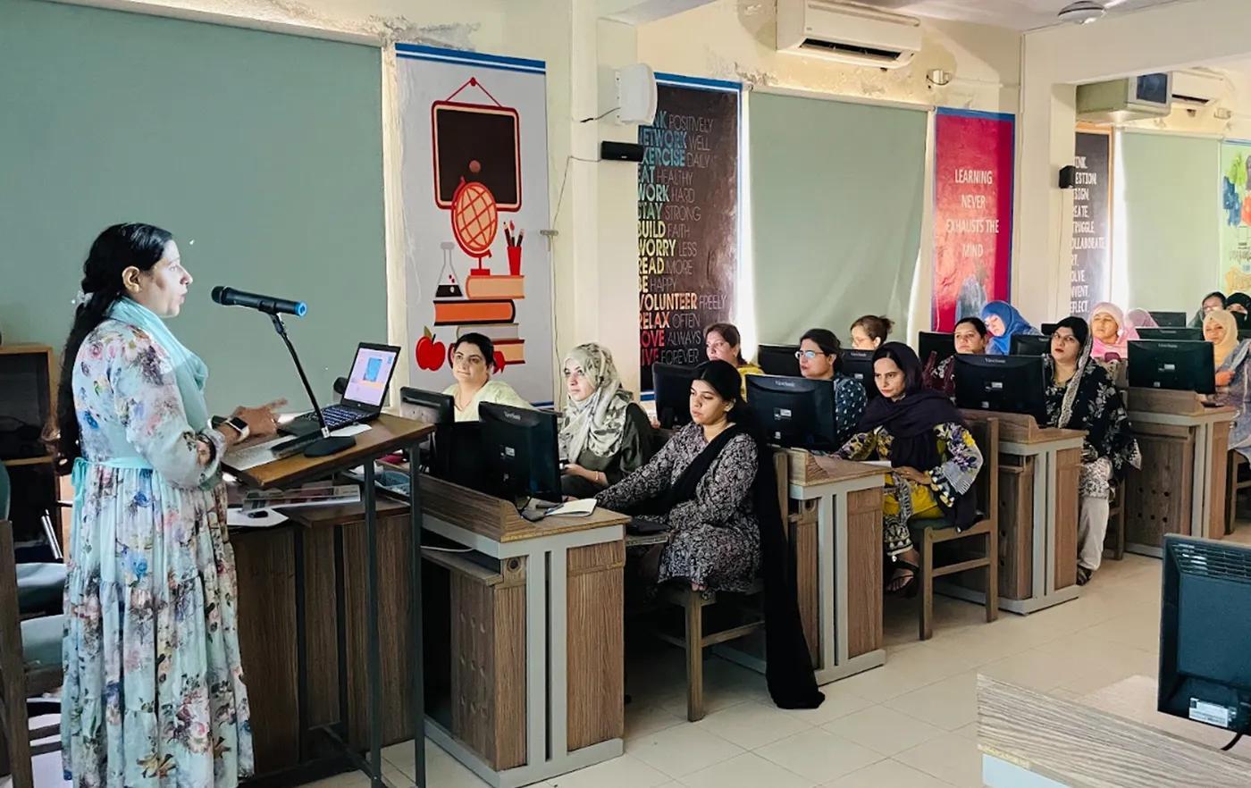 A trainer presenting to teachers in a school computer lab