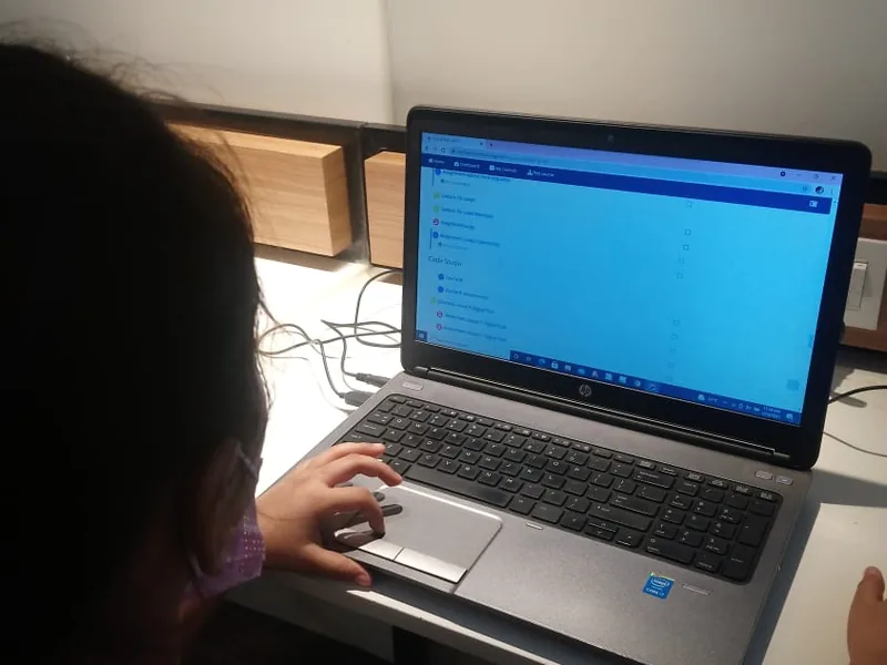 A student typing code on a laptop