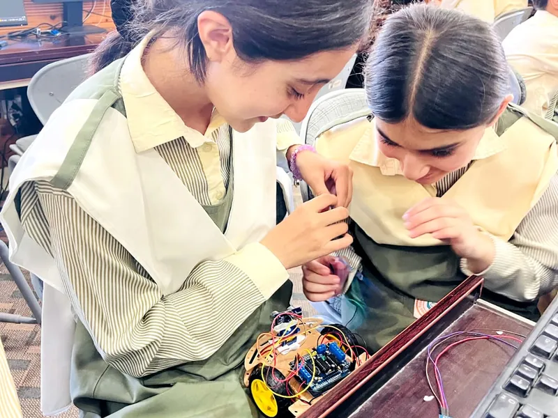 Two students assembling a robot car kit