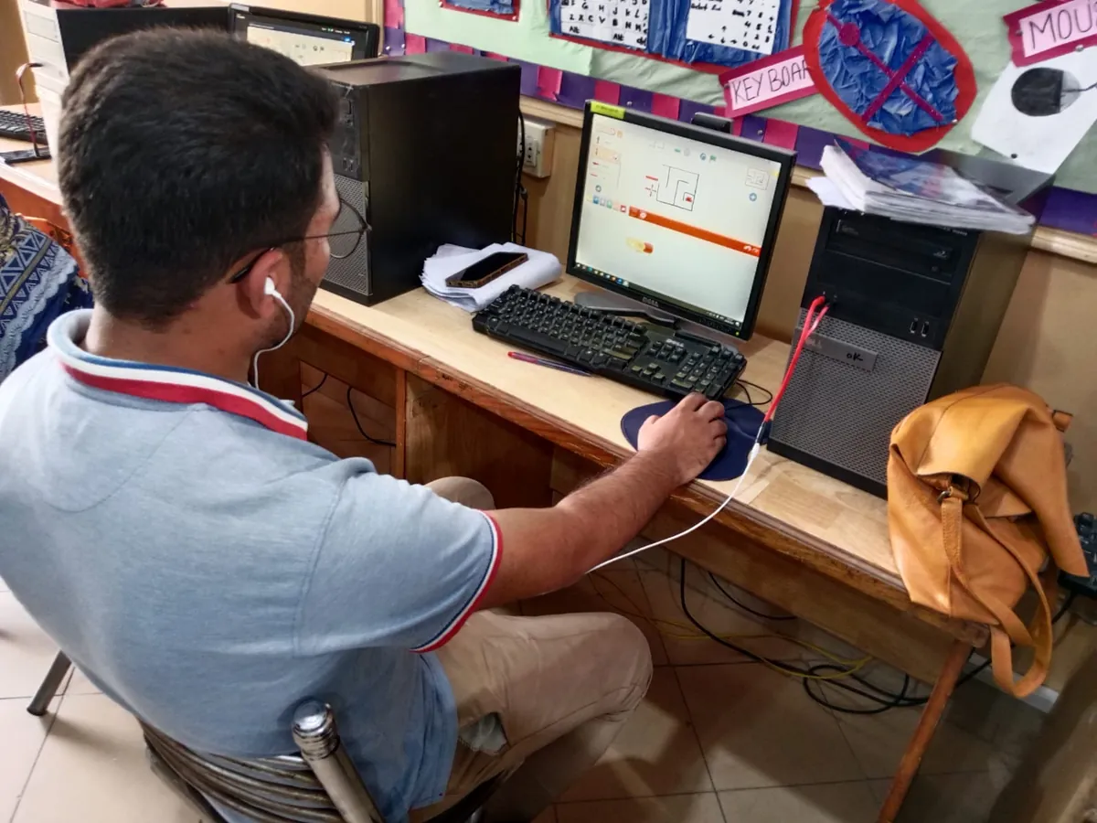 A student coding on a desktop computer in an ITEC class