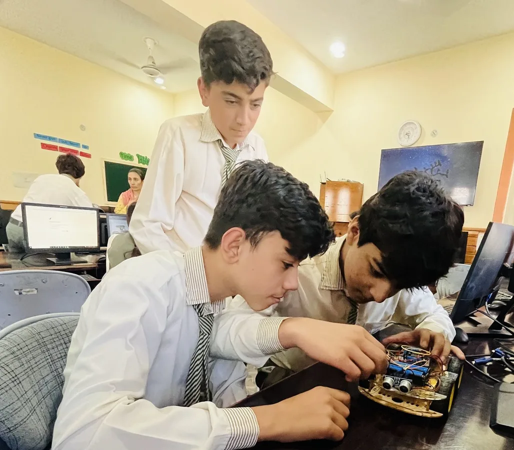 Students wiring an Arduino robot car with an ultrasonic sensor in their school lab