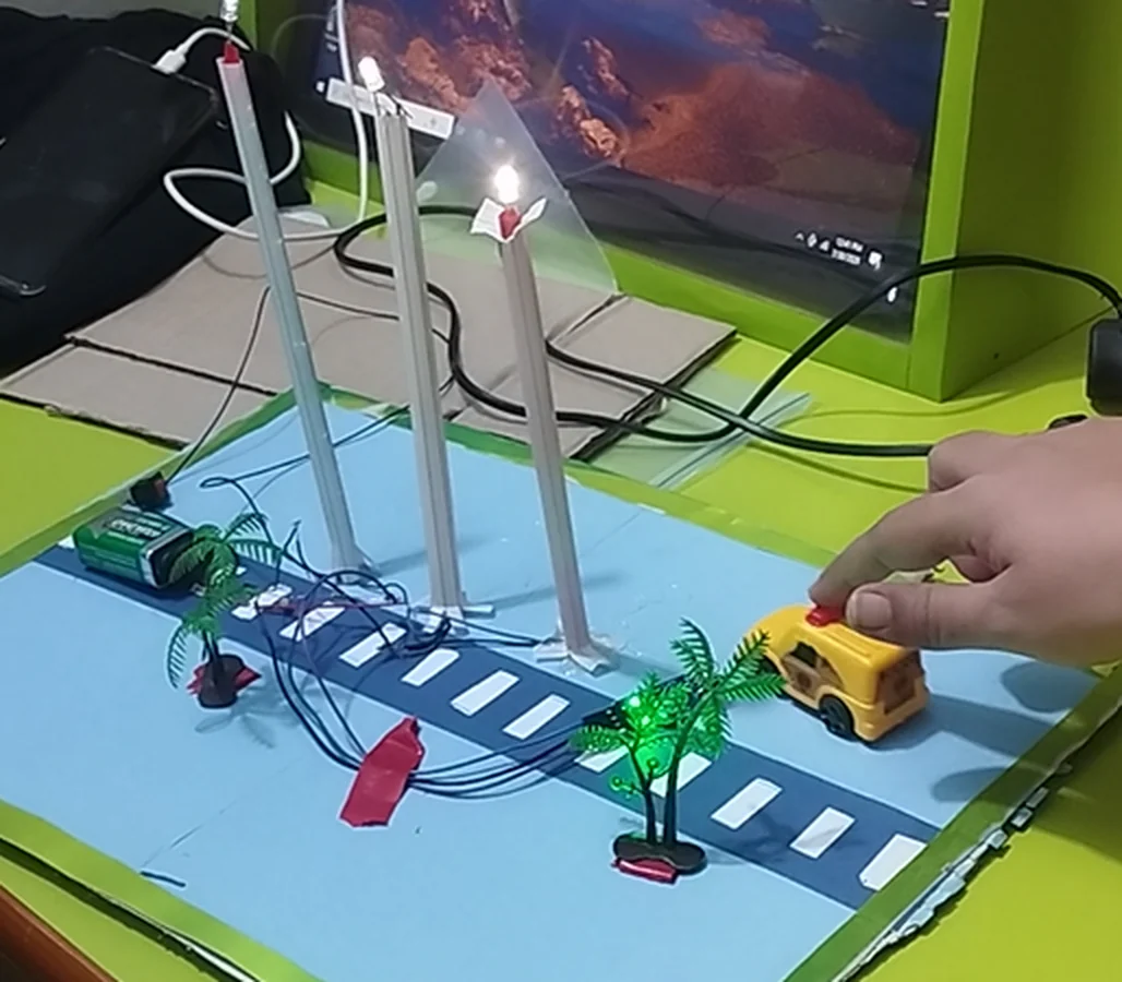 Students' smart street light model with working lights and a toy car