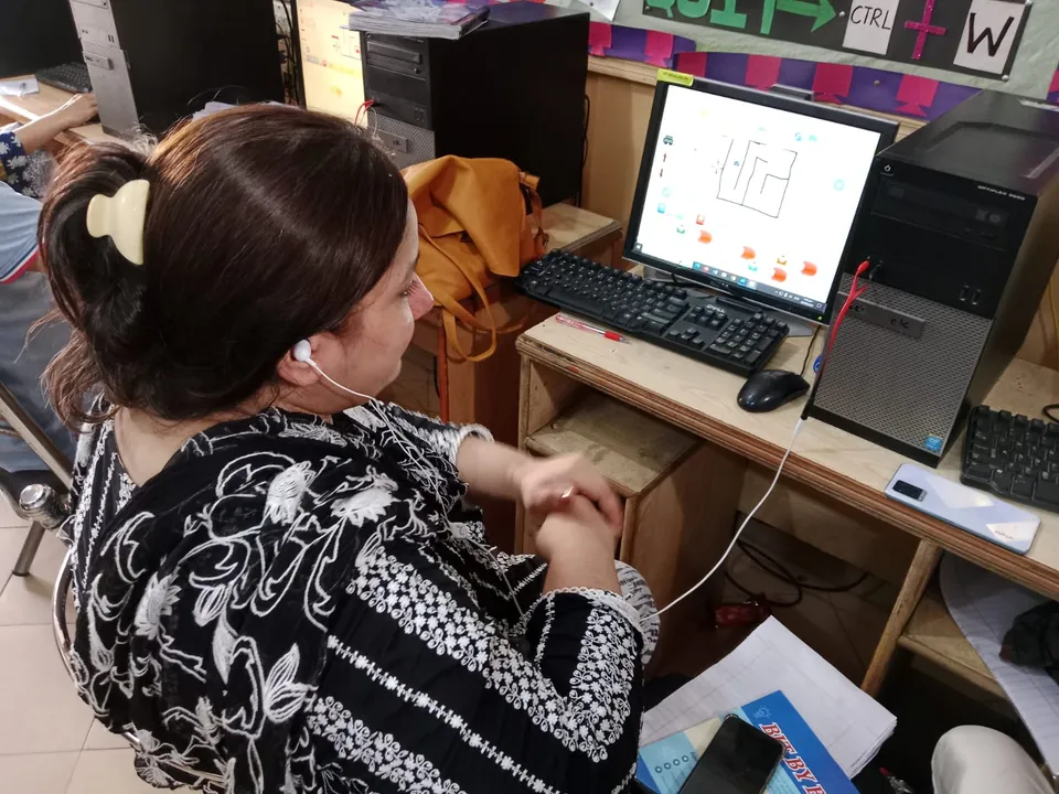 A teacher working through a coding exercise in the computer lab