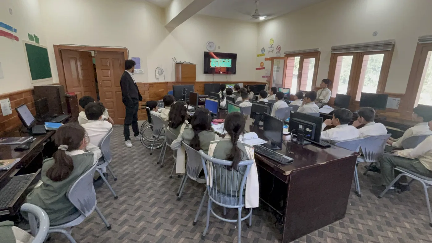 Students working in a school computer lab while school staff observe