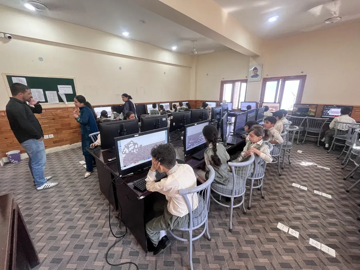 A Technoknowledge team member observing a computer class during a school visit