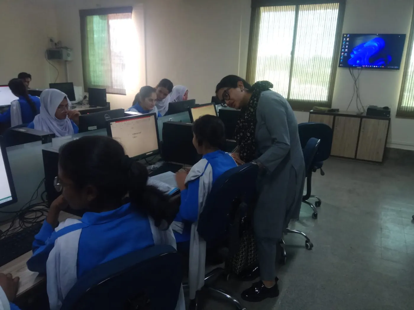 A Technoknowledge team member checking a student’s work in the computer lab