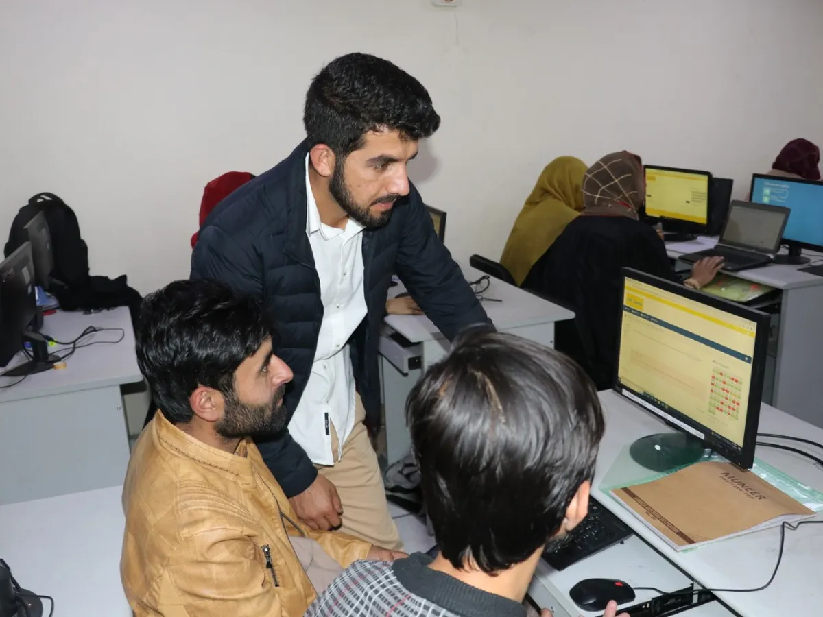 A trainer helping participants at their computers
