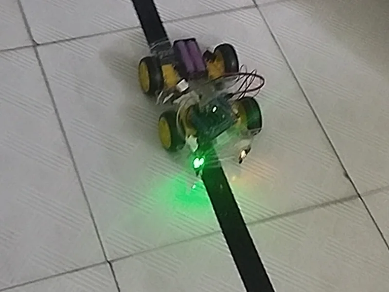 A line-following robot built by students moving along a black track