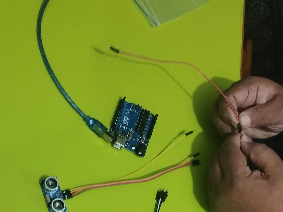 Hands wiring an ultrasonic sensor to an Arduino board