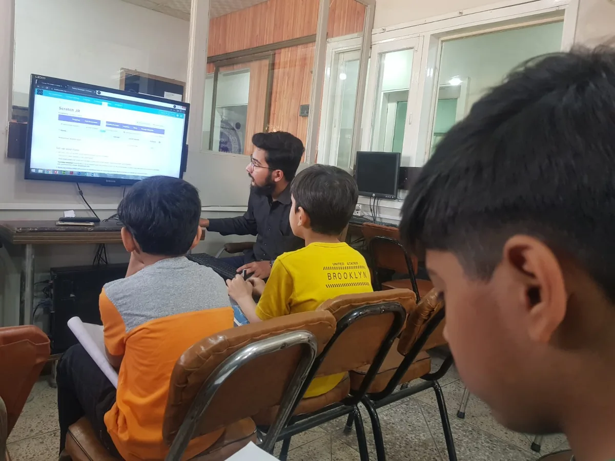 Students working with a trainer in a computer lab