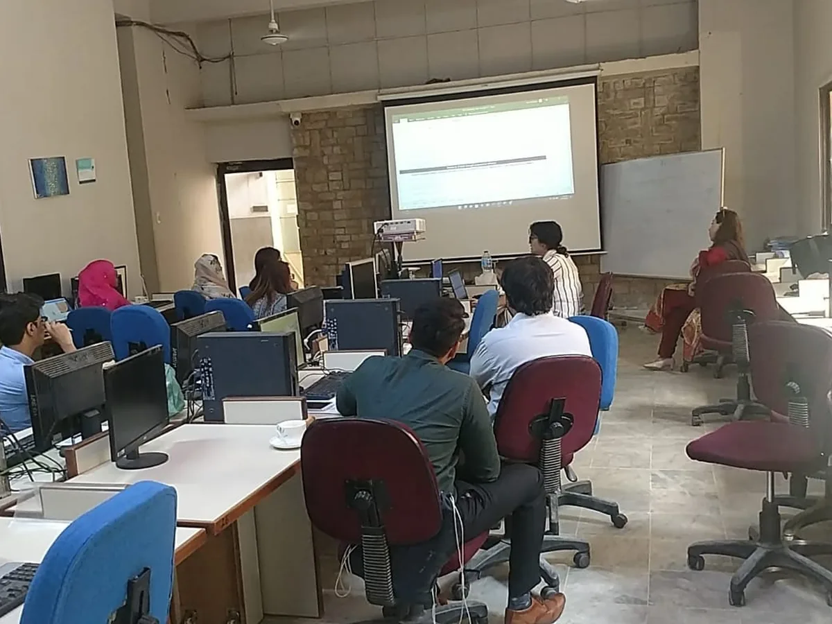 Teachers following a trainer's demonstration in a computer lab